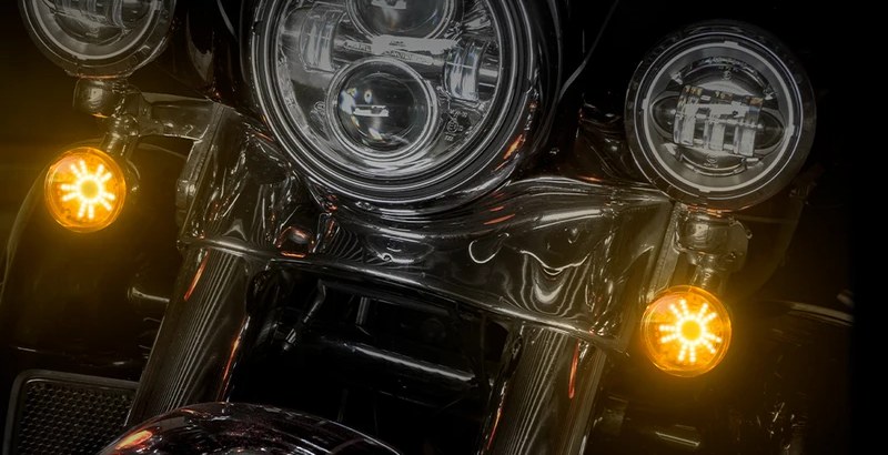 Close view of two amber star-pattern LED turn signal inserts lit on a motorcycle front end