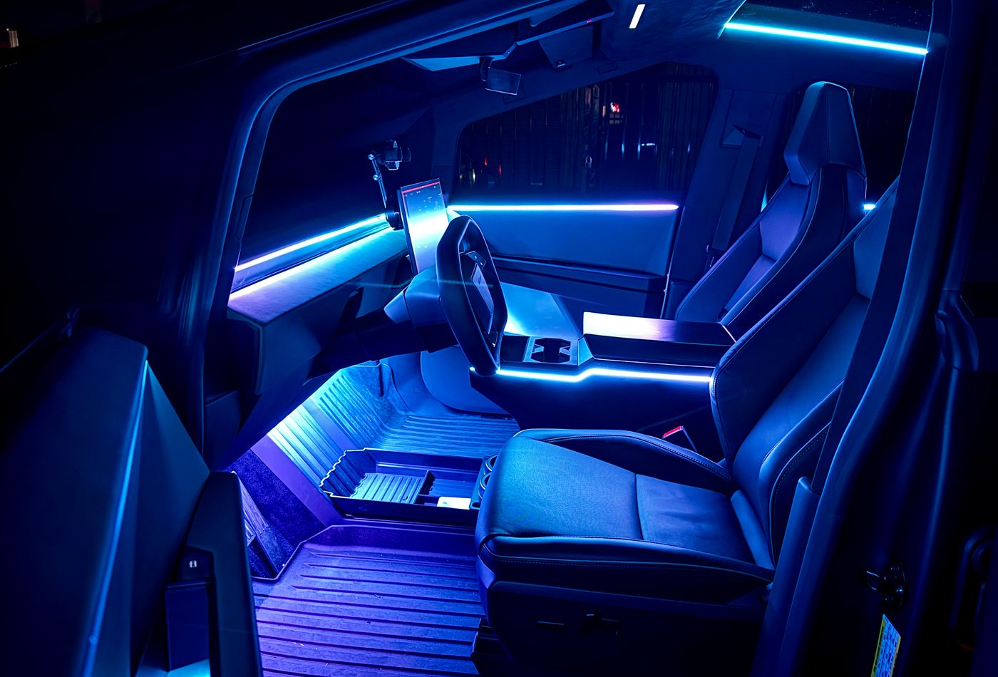Tesla Cybertruck interior with blue fiber-optic lighting along the doors, dash, and seats