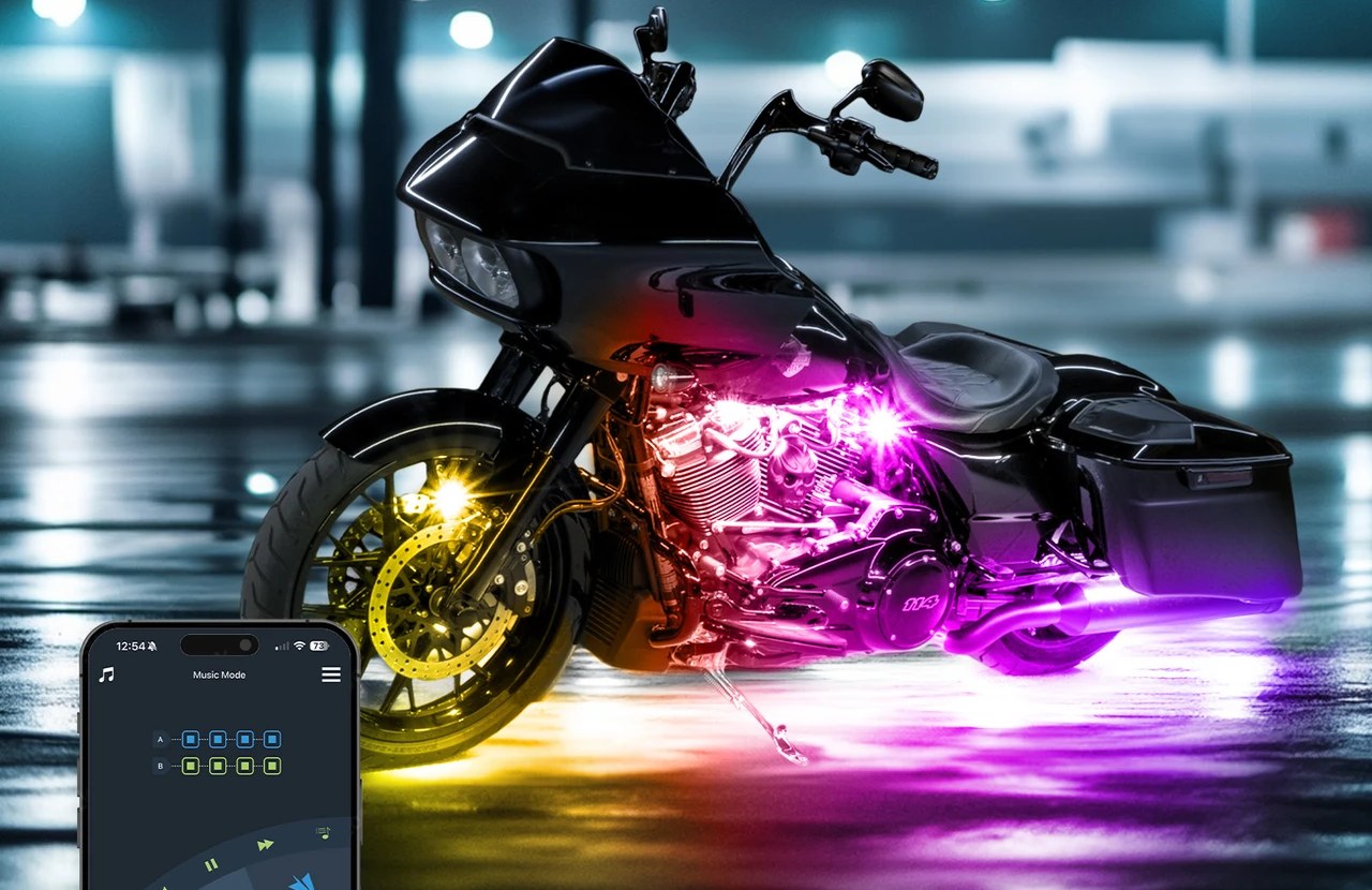 Touring motorcycle on wet pavement with magenta and yellow underglow, beside a phone showing the app's Music Mode