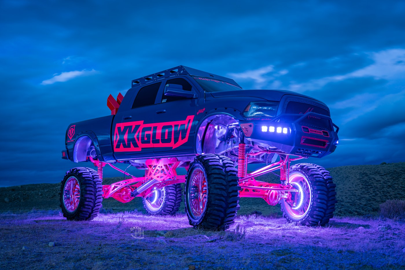 Lifted XKGLOW show truck with pink wheel ring lights and underglow at dusk